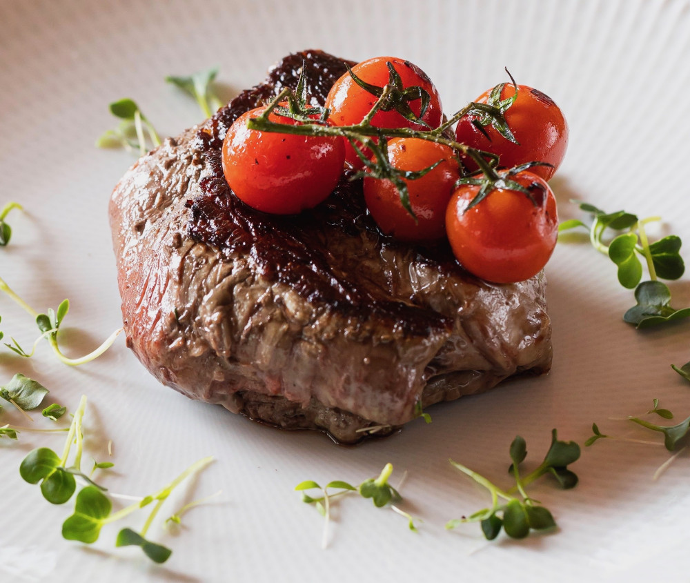 Aged beef tenderloin steak with cherry tomatoes and microgreens
